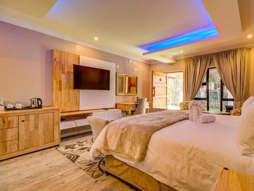 een slaapkamer met een groot bed en een flatscreen-tv bij Eagle Rock Executive Guest House in Kempton Park