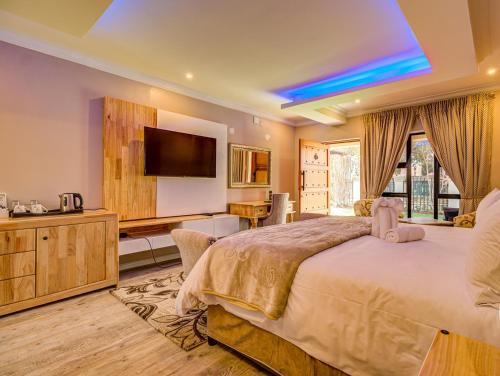 a bedroom with a large bed and a flat screen tv at Eagle Rock Executive Guest House in Kempton Park