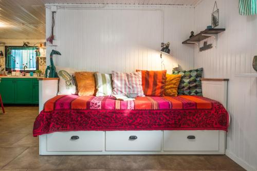 un sofá con almohadas coloridas en una habitación en Boho House 1 in camp Terme Catez, en Čatež ob Savi