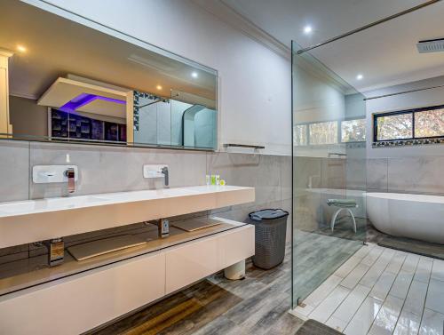 uma casa de banho com uma banheira e um lavatório e uma banheira em Eagle Rock Executive Guest House em Kempton Park