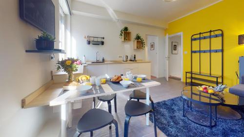 une cuisine et une salle à manger avec une table et des chaises dans l'établissement Suite privative 43m2 - Les tailleurs à 120m de la cathedrale, à Strasbourg