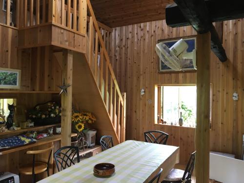 a kitchen and dining room with wooden walls and a table at 【1日1組限定】長野県・安曇野の一軒家貸切宿 「うまや UMAYA」 in Matsukawa