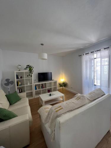 een woonkamer met twee witte banken en een tv bij Casa centro old town in Estepona