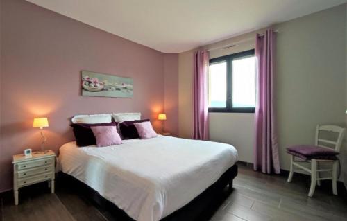 1 dormitorio con 1 cama grande con almohadas moradas en Maison avec Piscine intérieure privée sans vis à vis chauffée toute l année, en Quiévrecourt