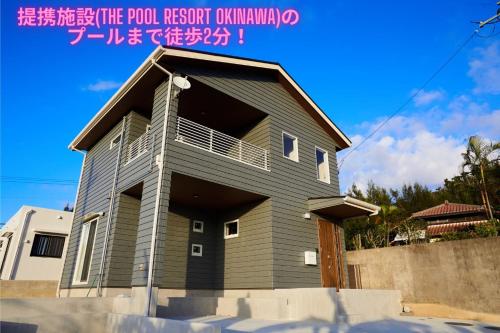 a house with a balcony on top of it at The Pool Resort Villa ICHIGOICHIE in Onna