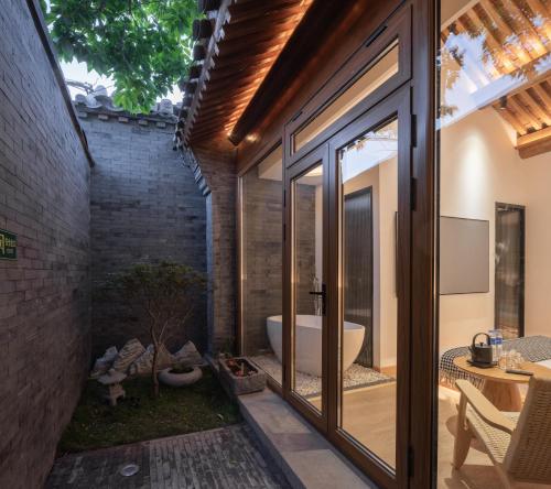 La salle de bains est pourvue de portes coulissantes en verre et d'une baignoire. dans l'établissement Beijing wu tong, à Pékin