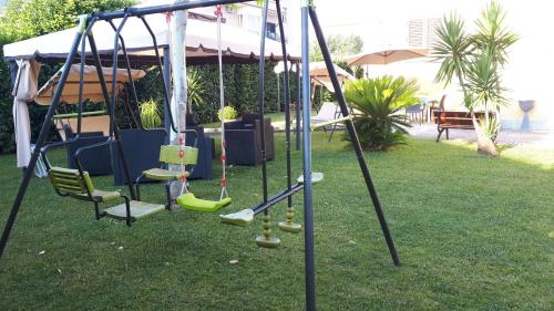 a swing set in a yard with grass at B&B Villa Rosa in SantʼAntonio Abate