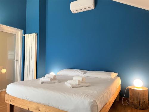 Un dormitorio azul con una cama con toallas. en Attico Paderno Dugnano - Milano, en Paderno Dugnano