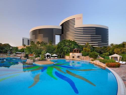 una gran piscina frente a un complejo en Grand Hyatt Dubai en Dubái