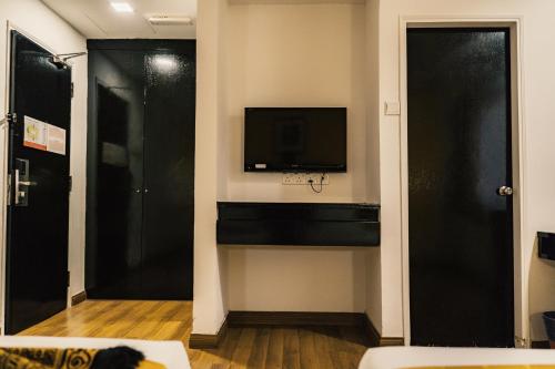 a living room with a flat screen tv and a living room at Hotel Sentral Riverview Melaka in Melaka