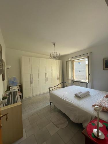 una camera da letto con un grande letto bianco e una finestra di Alloggio Flaminia con parcheggio di proprietà! a Bevagna