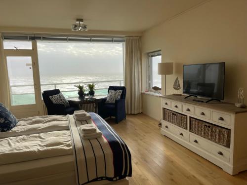 - une chambre avec un lit et une télévision à écran plat dans l'établissement The wave, à Zandvoort