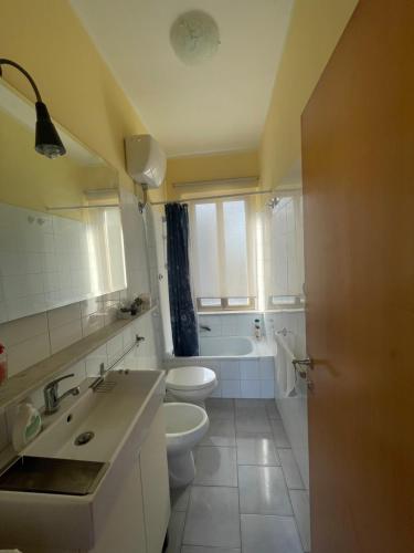 a bathroom with two toilets and a sink and a tub at Alloggio Flaminia con parcheggio di proprietà! in Bevagna