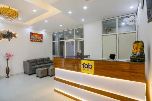 a hotel lobby with a reception desk and a couch at FabExpress Premium Luxury Stay in Noida