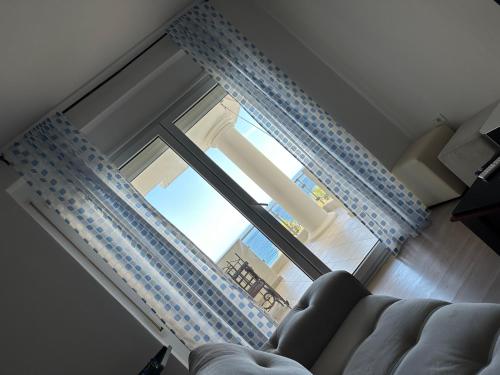 a living room with a couch and a sliding glass door at Appartamento Saranda in Sarandë