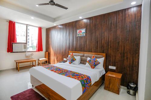 a bedroom with a bed and a wooden wall at FabExpress Premium Luxury Stay in Noida
