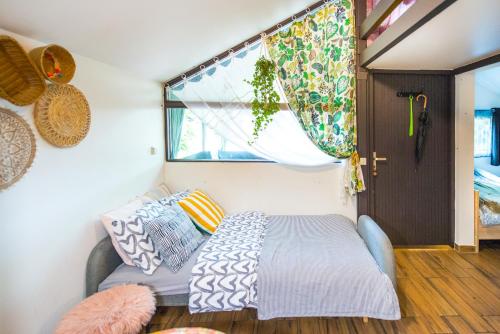 a bed in a room with a window and a couch at Boho House 3 camp Terme Catez with promotional tickets prices in Čatež ob Savi