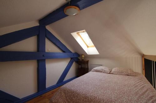 a bedroom with a blue and white bed and a window at DOMAINE DES GRAVIERS in Plainfaing