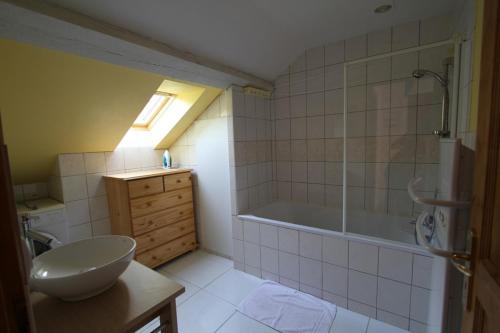 un bagno con vasca e lavandino di DOMAINE DES GRAVIERS a Plainfaing
