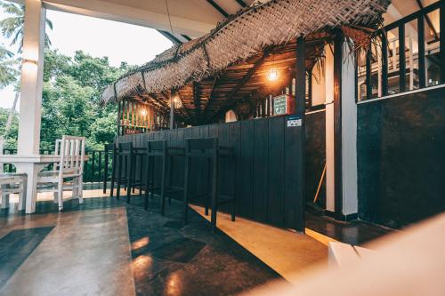 a bar with a green fence and chairs on a porch at Samudra Beach Resort in Tangalle