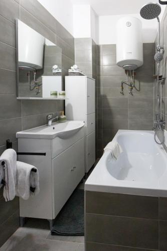 a white bathroom with a sink and a tub at Casuta cu View in Sighişoara