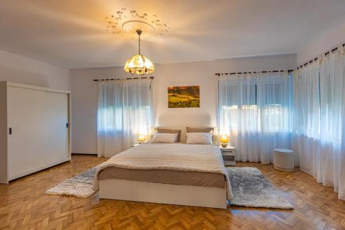- une chambre avec un grand lit et un lustre dans l'établissement Casuta cu View, à Sighişoara