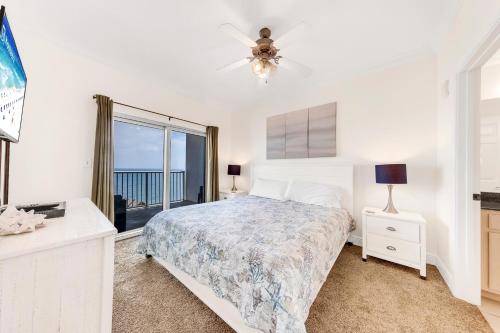a white bedroom with a bed and a window at Crystal Tower 1506 in Gulf Shores