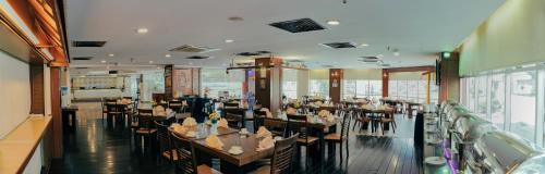 a dining room with tables and chairs in a restaurant at Hotel Sentral Riverview Melaka in Melaka