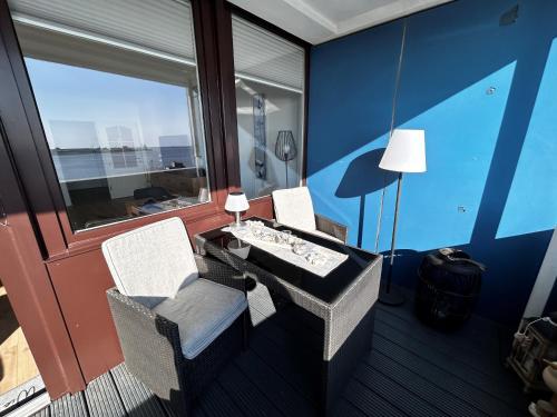 een kamer met 2 stoelen, een tafel en een raam bij Ferienwohnung Havenwelten in Bremerhaven