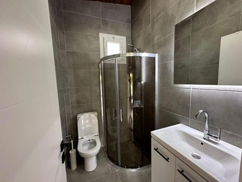 a bathroom with a shower and a toilet and a sink at Ovacık Villa Bungalows Çeşme in Çeşme