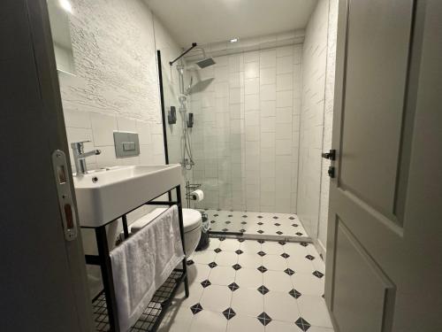 a white bathroom with a sink and a toilet at Arcadia Butik Otel in Canakkale