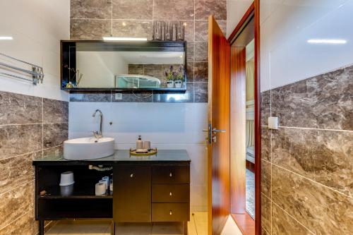 W łazience znajduje się umywalka i lustro. w obiekcie Garden in Town Hostel w Porto