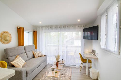 a living room with a couch and a table at Soleil d'Été - Netflix & Wifi - Balcon - Climatisation - Parking Gratuit - check-in 24H24 - Emplacement Vélos - GoodMarning in Châlons-en-Champagne