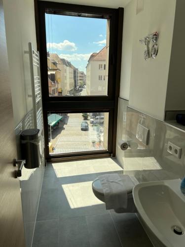 a bathroom with a large window and a sink at NB Apartments in Nuremberg