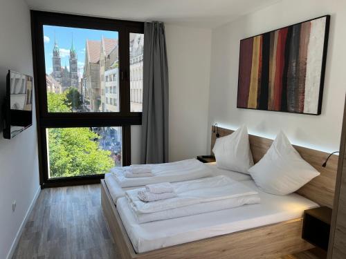 a bedroom with two beds and a large window at NB Apartments in Nürnberg