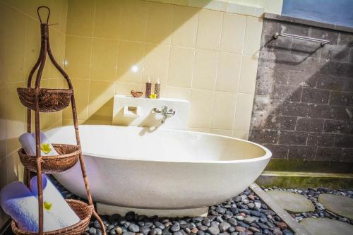 a white tub in a bathroom with a shower at Villa JJ and Spa Ubud in Ubud