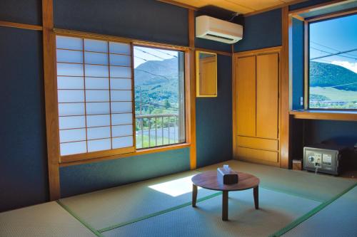 a room with a table and two windows at root hakone in Hakone