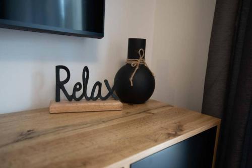グラーツにあるStilvolle 2-Zimmer Wohnung in Graz-Lendの木製テーブルの上に座る黒花瓶