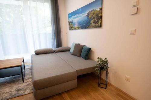 Stilvolle 2-Zimmer Wohnung in Graz-Lend في غراتس: أريكة في غرفة معيشة مع نافذة