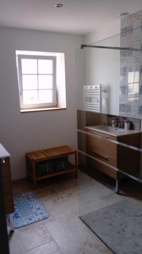 une salle de bain avec un lavabo et une fenêtre dans l'établissement La Vignellerie du Lac, à Hommes