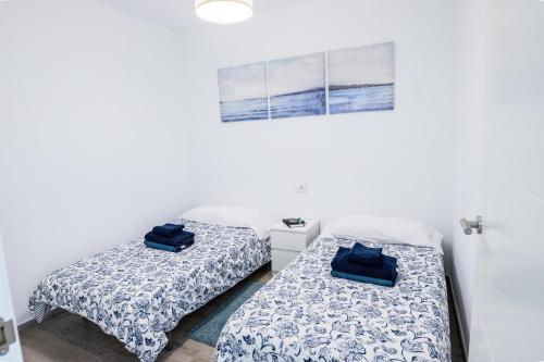 twee bedden in een kamer met witte muren bij Maresia in Arrieta