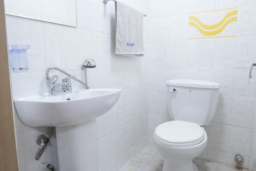 La salle de bains blanche est pourvue de toilettes et d'un lavabo. dans l'établissement Anire, à Busan