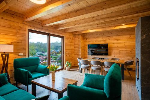 a living room with green chairs and a table at Chalet Martuška - Drevenica so saunou - Celá dolina len pre vás in Levoča