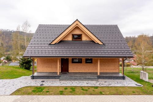 ein kleines Haus mit schwarzem Dach und einer Veranda in der Unterkunft CHALET Martuška in Levoča