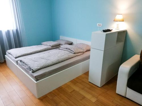 een kleine slaapkamer met een bed en een witte dressoir bij CityMo in Mostar