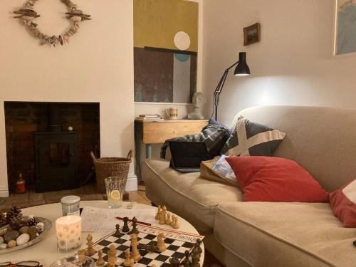 a living room with a couch and chess board on a table at Pretty coastal victorian cottage in Yarmouth IOW in Yarmouth