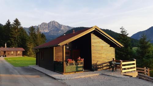eine Blockhütte mit einem Balkon und einem Berg in der Unterkunft Ferienhütte Sonnreith in Spital am Pyhrn