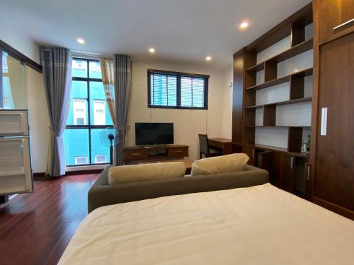 - une chambre avec un lit, un canapé et une télévision dans l'établissement Hi.Home House near Lake, à Hanoï