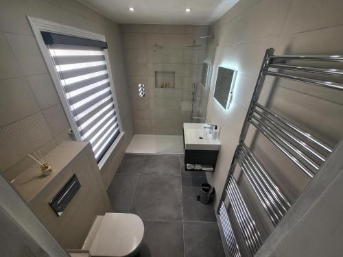 bagno con doccia, lavandino e servizi igienici di Sunset Point Apts - North Shore Suite a Margate