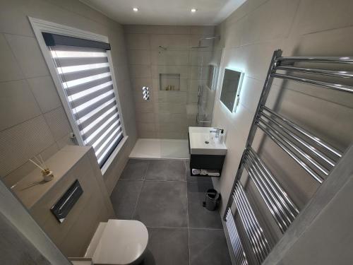 a bathroom with a shower and a sink and a toilet at Sunset Point Apts - North Shore Suite in Margate